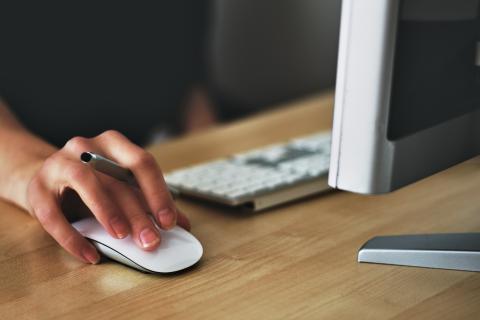 Detail of a person's hand clicking on a mouse