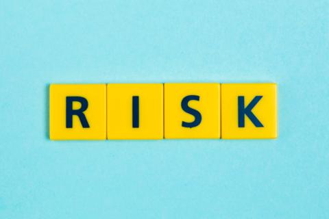 Risk written used the Scrabble tiles on a light blue background