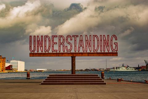 The word "Understanding" appearing as an art work on a coastal shore